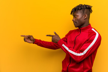 Young fitness african man excited pointing with forefingers away.