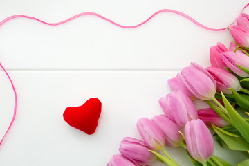Pink tulips and love heart isolated on white wood Background.