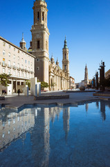 Zaragoza, Aragon, Spain, 2019 : Bell towers of Our Lady of the Pillar basilica reflected on the (Fountain of Hispanicity) at the Plaza del Pilar square. 