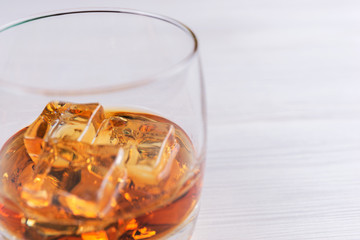 Glass of scotch whiskey isolated of a bright wooden table