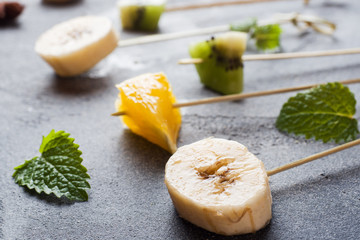 Fresh fruit on skewers for fondue. Table for summer party