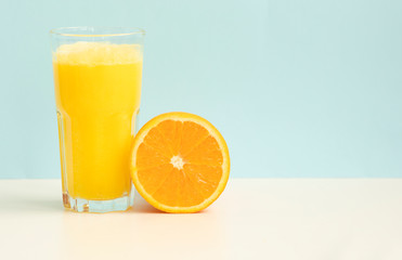 Fresh orange juice on blue background
