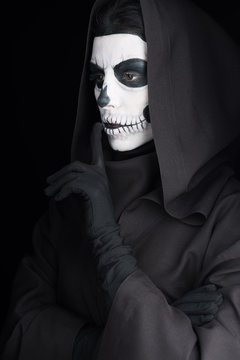 woman with skull makeup showing hush sign isolated on black