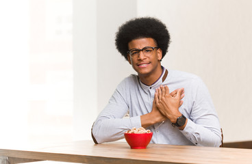 Fototapeta na wymiar Young black man having a breakfast doing a romantic gesture