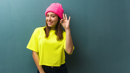Young modern woman cheerful and confident doing ok gesture