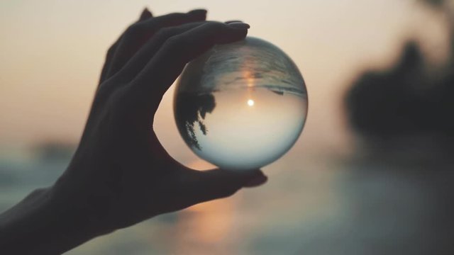 Woman hand with prism at beach