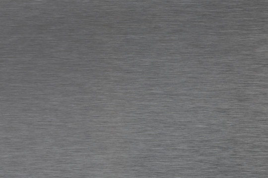 Close up industrial background of fractally scratched direct horizontal lines to silver metal/stainless steel surface. Creative detail macro photography.