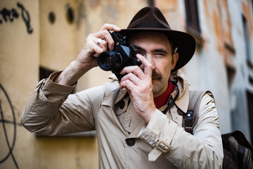 Detective taking pics in a sity slum with his vintage camera