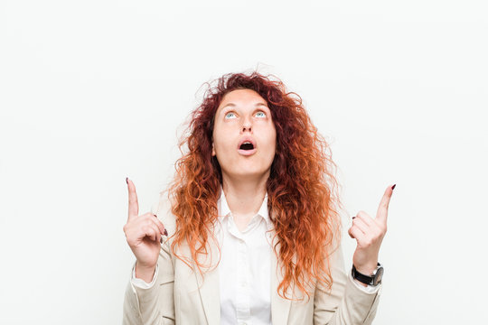 Young Natural Redhead Business Woman Isolated Against White Background Pointing Upside With Opened Mouth.