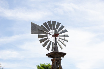 A vintage windmill against a cloudy sky