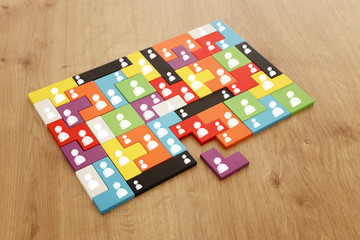 image of tangram puzzle blocks with people icons over wooden table ,human resources and management...