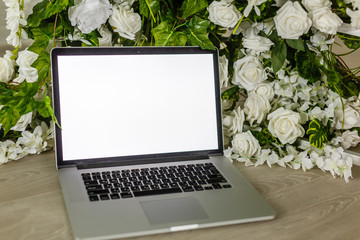 Home office desk with blank screen laptop, beautiful roses and eucalyptus bouquet, Blog, website or...