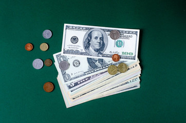 A stack of dollar bills on a green background.