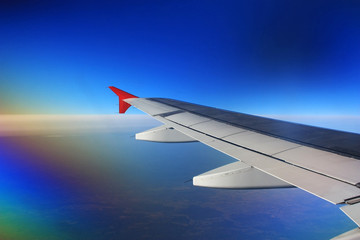 Airplane wing in the blue sky