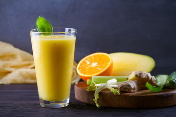 Fototapeta premium Mango Orange Ginger Cucumber and Celery Smoothie. Fruit and Vegetable Smoothie - healthy diet and detox drink. horizontal
