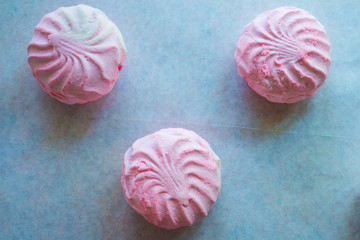 Pink and white marshmallows on parchment paper