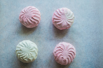 Pink and white marshmallows on parchment paper