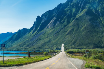 Roads and natural landscape in the heart of Lofoten. Gimsoystraumbrua bridge is one of many bridges that connect the islands of Lofoten to each other as part of the European route E10 highway - obrazy, fototapety, plakaty