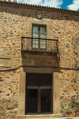 Fototapeta na wymiar Building stone facade with door entrance and balcony at Caceres