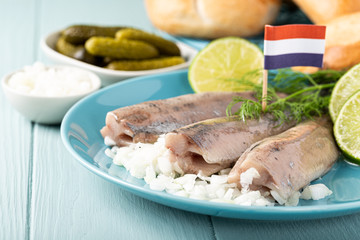 Traditional dutch food freshly salted herring fish with onion called hollandse nieuwe. European food concept with copy space.