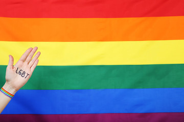 Female palm with abbreviation LGBT on rainbow flag background