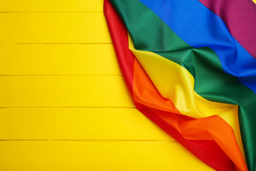 Rainbow flag on yellow wooden table