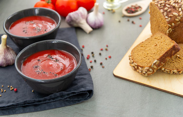 Cold tomato gazpacho soup in a deep plate on a stone background. Traditional Spanish cuisine. The...