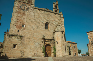 Gothic church facade with steeples and wooden door at Caceres