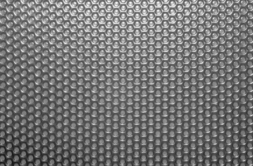 Many round holes in the metal case close-up