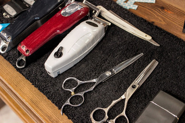Hairdressing tools. Scissors, thinning scissors, comb, clippers, edging machine. They lie on a...