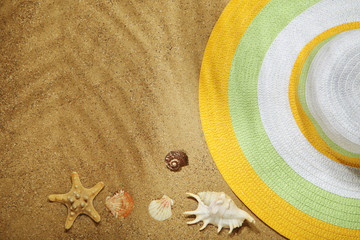 Fototapeta na wymiar Seashells with beach hat on sand
