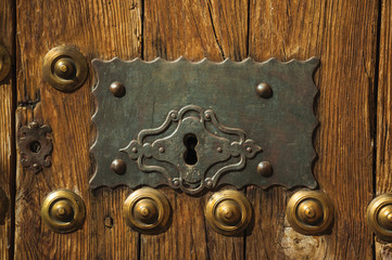 Bronze studs and wrought iron keyhole in an old door at Caceres
