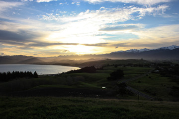 Fototapeta na wymiar Colorful sunset over the meadows and the mountain range of the east coast of the North Island, New Zealand