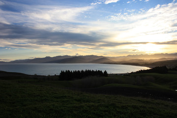 Colorful sunset over the meadows and the mountain range of the east coast of the North Island, New Zealand
