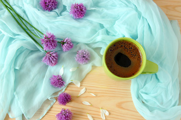 cup of coffee and flowers on wooden table