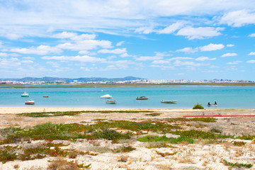 Praia De Faro, Algarve, Portugal. Aerial view on coast of ocean and beach. Boats on water, drone view 