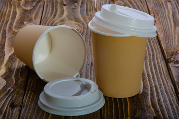 Paper cup for coffee. Wooden table.