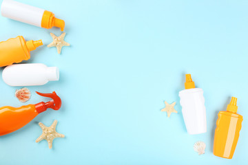 Sunscreen bottles with seashells and on blue background