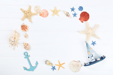Seashells with decorative anchor and ship on white table