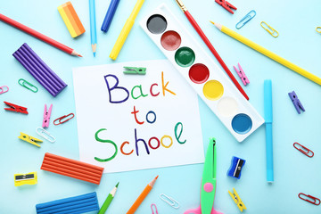 Inscriptions Back To School with school supplies on colorful background