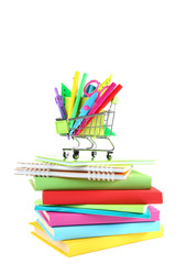 School supplies in shopping cart with books on white background