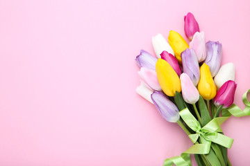 Bouquet of tulip flowers with ribbon on pink background