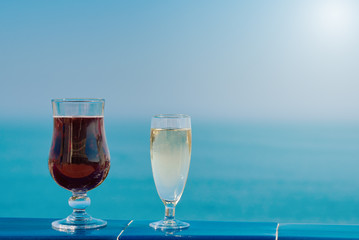 Enjoying the honeymoon. Two wineglasses against the picturesque ocean view.