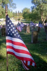 Portrait of American flag flying at soldiers tombstone