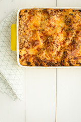 Italian Lasagna Bolognese with Beef, Cheese and Tomato Sauce on Rustic White Wooden Background