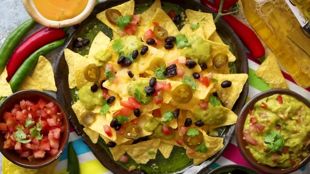 Mexican nachos tortilla chips with black bean, jalapeno, guacamole