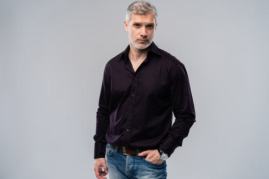 Cheerful Man Of Middle Age Against White Background, Wearing Jeans And Black Shirt, Mid Shot.