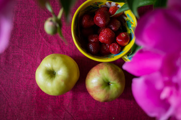 Apples and srawberry on the kitchen table.