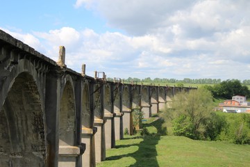 View of an old abandoned viaduct under a blue sky with white clouds