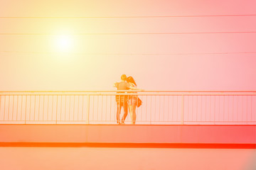 Young couple in love takes selfie portrait on the bridge. Yellow orange toned